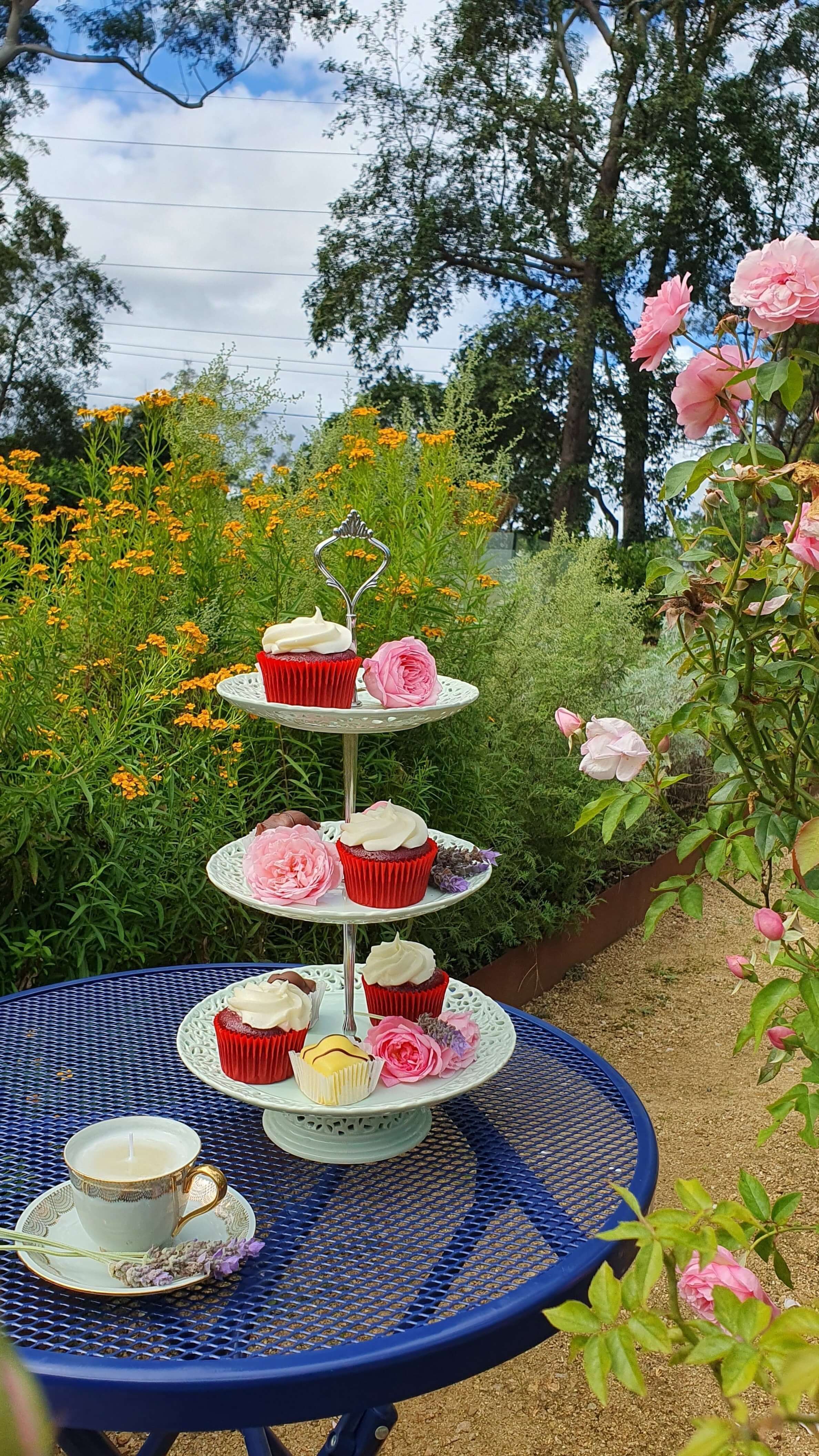 A tiered platter with cupcakes in a garden